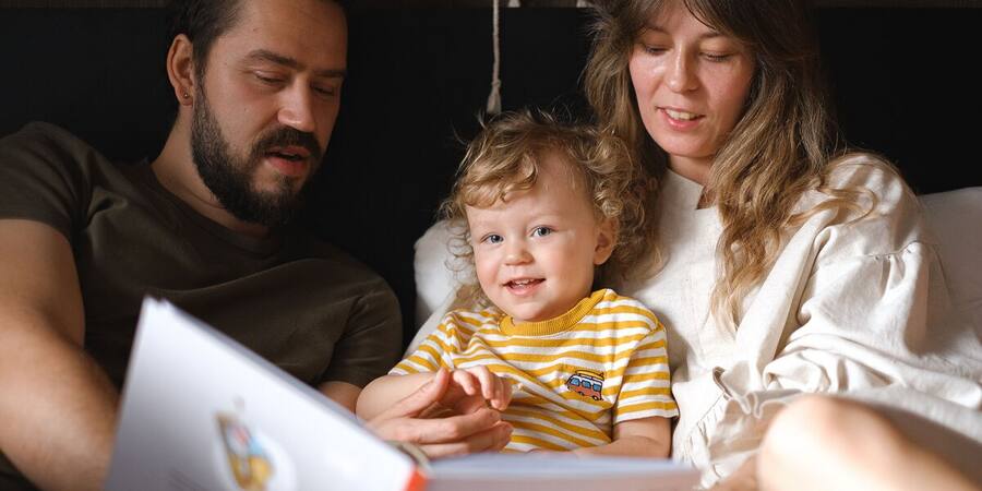 Familia leyendo y practicando junto a su hija en un ambiente cálido en casa